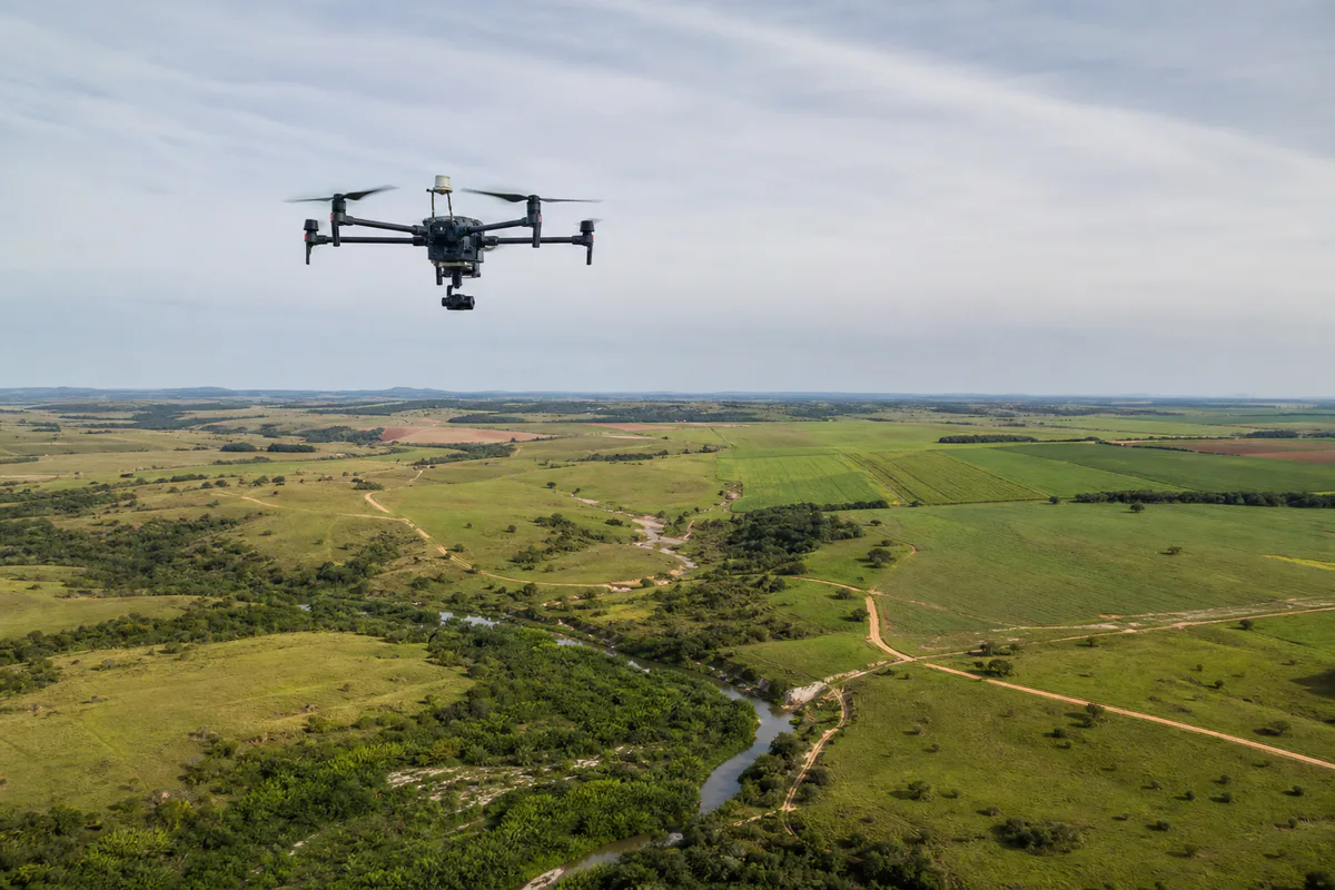 Drone de mapeamento realizando aerolevantamento sobre área rural
